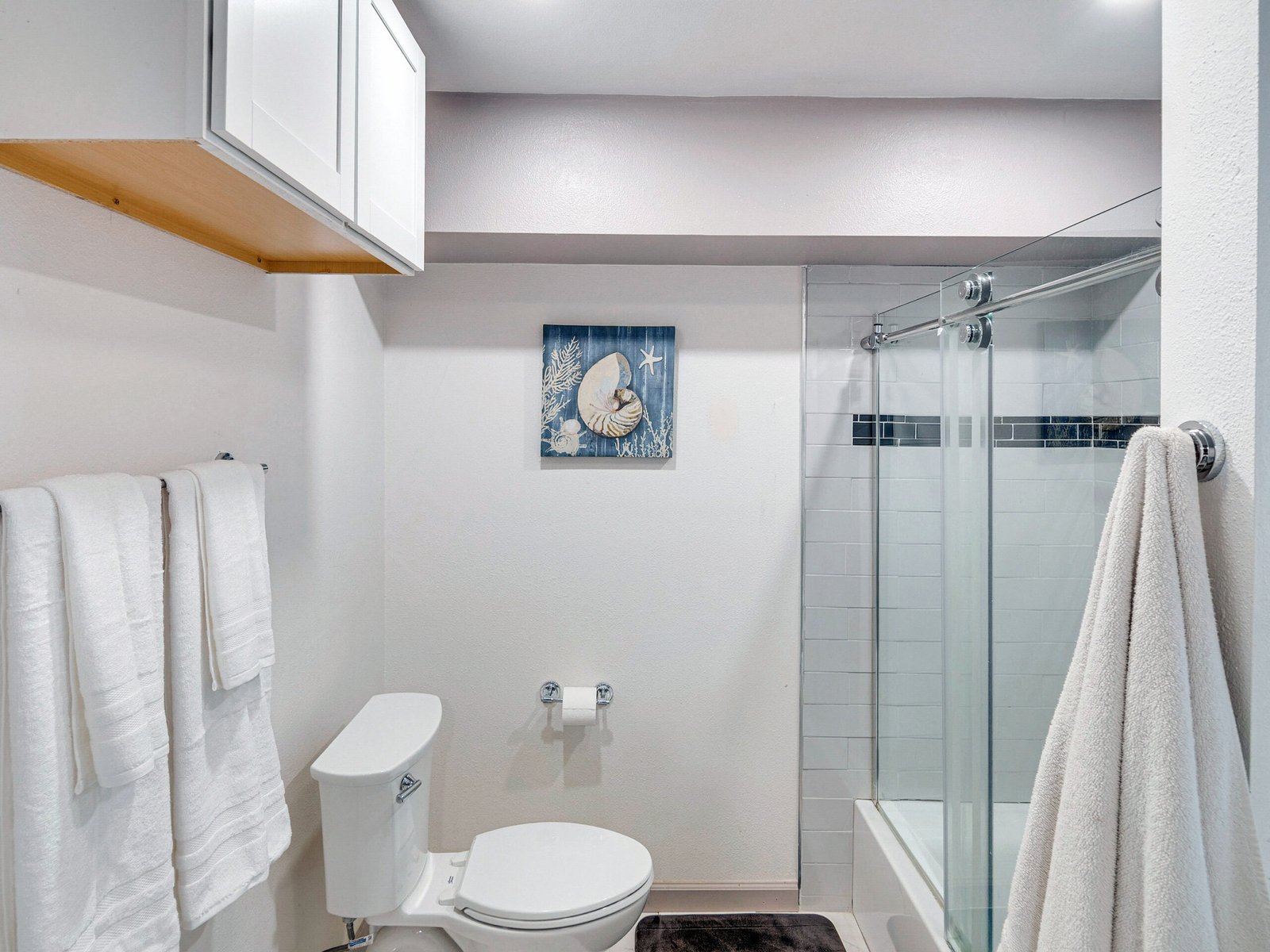 Newbury Park Vacation Rental | The Surf Retreat Modern 1BR 13 Bright and modern open-concept living room and kitchen space with cozy gray sectional, flat-screen TV, and fully equipped white kitchen – perfect for long-term or short-term rentals, sober living homes, and military housing.