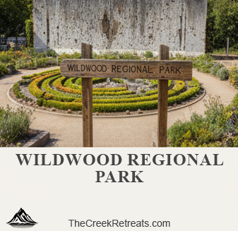 A wooden sign for Wildwood Regional Park in front of a circular garden maze, featuring the Creek Retreats logo.